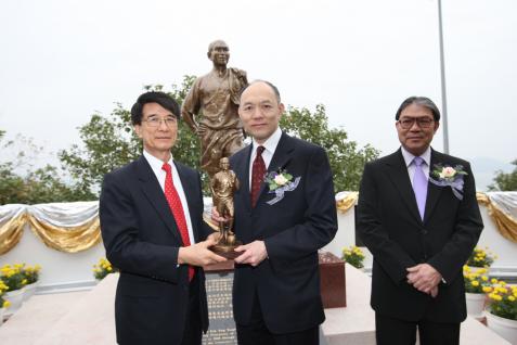 朱 經 武 校 長 (左) 致 送 小 型 銅 像 紀 念 品 給 霍 震 寰 先 生 ； 旁 為 霍 震 霆 先 生	