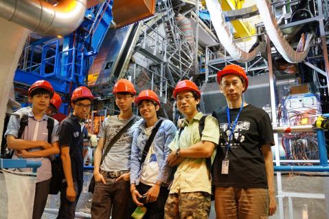  部分香港物理学家团队的成员，背后为ATLAS探测器。