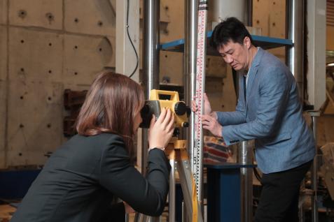 To build bridges to civil engineering knowledge related to social issues, Prof. Thomas Hu (right) took his students to different locations to measure the settlement levels.