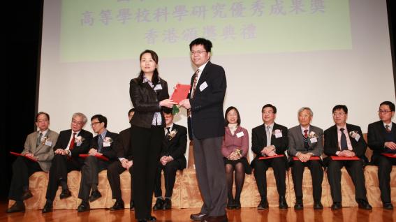 王 文 雄 教 授 （ 右 ） 接 受 國 家 教 育 部 科 技 發 展 中 心 副 主 任 周 靜 女 士 頒 發 獎 勵 証 書	
