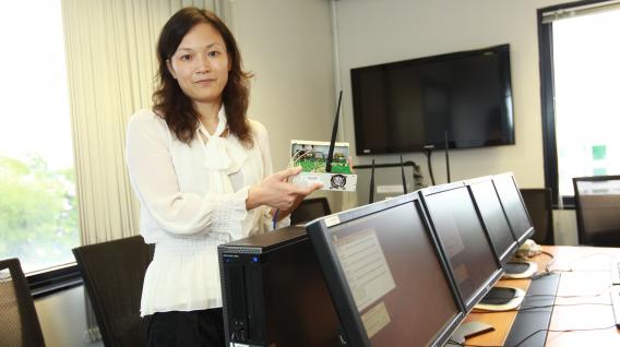 张 黔 教 授 讲 解 她 在 动 态 频 谱 管 理 和 认 知 无 线 电 技 术 上 的 研 究 突 破 。	
