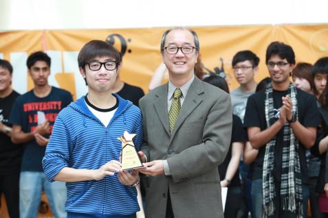 陳 繁 昌 校 長 頒 發 冠 軍 獎 座 給 表 演 節 奏 口 技 的 張 浩 漁 同 學 。	