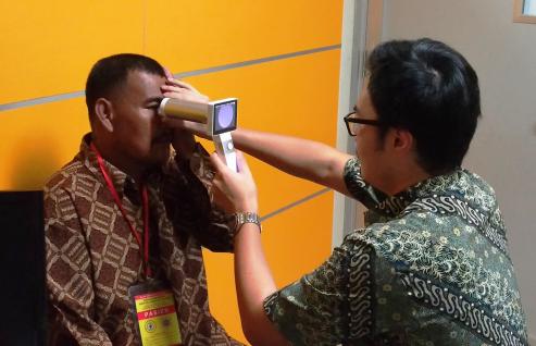  學生於印尼一間診所內，測試使用手提式眼底相機檢測糖尿眼的效果。