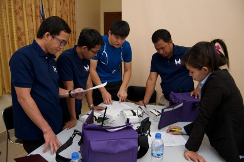  The student is demonstrating to the clinical staff in Cambodia how to use the mobile application of the electronic medical record system.