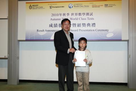 吳 大 琪 教 授 頒 發 証 書給 八 歲 的 黃 祉 臻 ； 黃 同 學 是 在 8 至 11 歲 組 別 測 試 中 獲 得 雙 優 的 最 年 輕 考 生 。	
